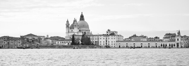 Photo view of buildings by sea against sky in city