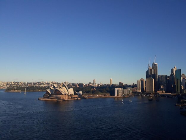 Photo view of buildings in city against clear blue sky