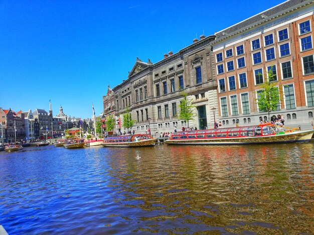 View of buildings in city against clear blue sky