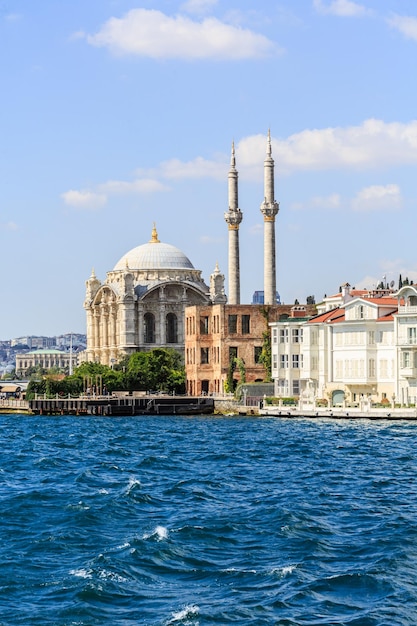 Photo view of buildings at waterfront against cloudy sky