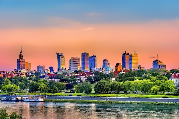 Photo view of buildings at waterfront during sunset