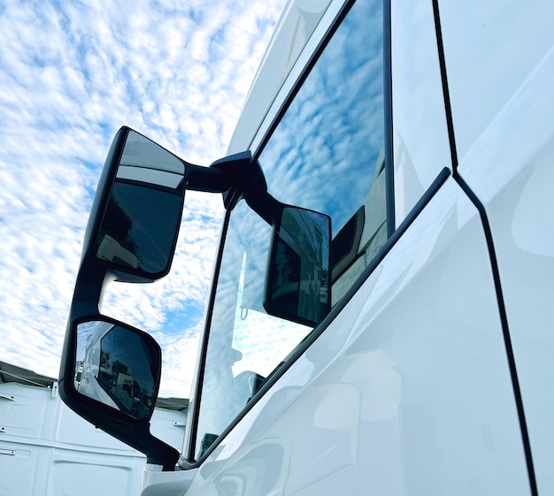 View of the cab of a truck with rear-view mirrors against the sky