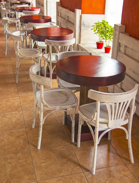Вид кафе с пустыми столами и стульями.