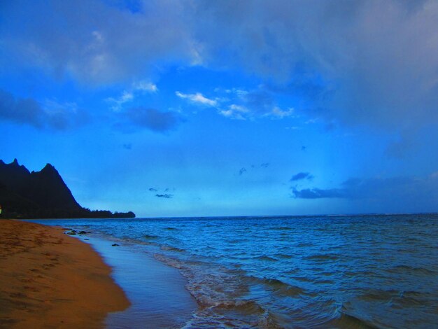 View of calm beach against blue sky