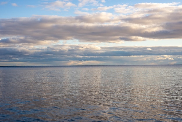 Вид на спокойное озеро на фоне предзакатных облаков
