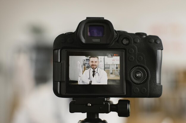 Photo view on camera screen with doctor putting on rubber gloves