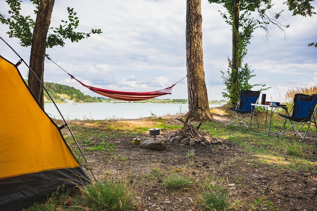 View of camping near lake with hammock between trees