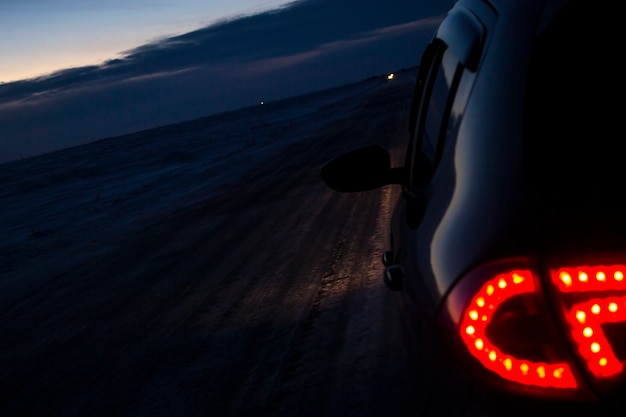 A view of the car on a snowcovered evening road