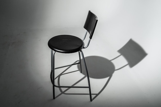 View of a chair in a photographic studio with its shadow