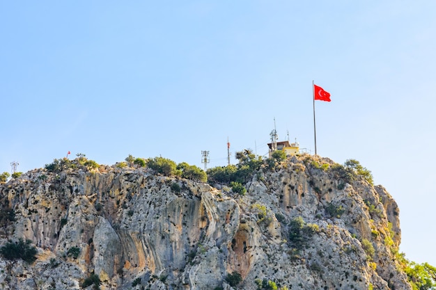 Vista sulla montagna di chalish e sulla bandiera turca sulla sommità non lontano dalla città di kemer. provincia di antalya, turchia