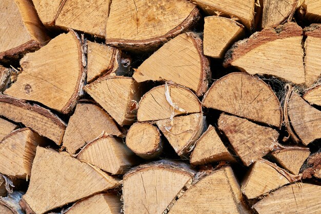 Above view of chopped firewood logs stacked together in storage pile Closeup of wooden background and texture Collecting dry rustic wood as a source of energy Lumber split hardwood with copyspace