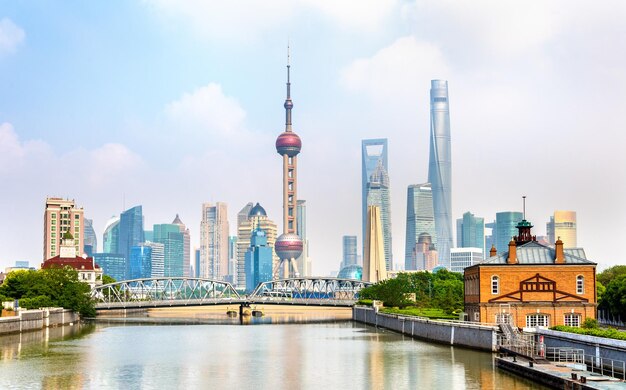 View of city buildings by river against sky