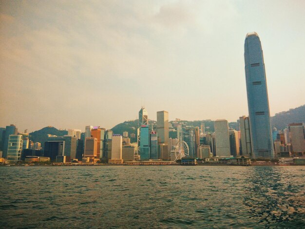 Photo view of city at waterfront during sunset