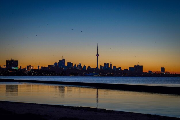 View of city at waterfront during sunset