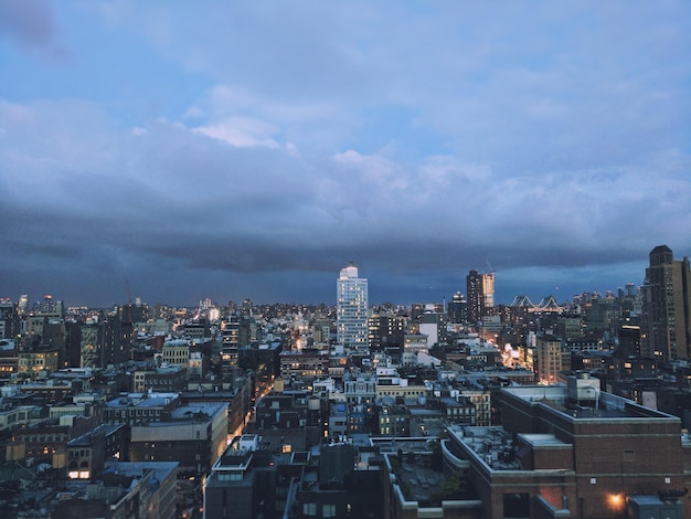 View of cityscape against cloudy sky