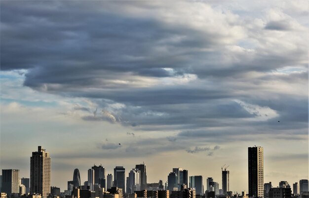 Photo view of cityscape against cloudy sky