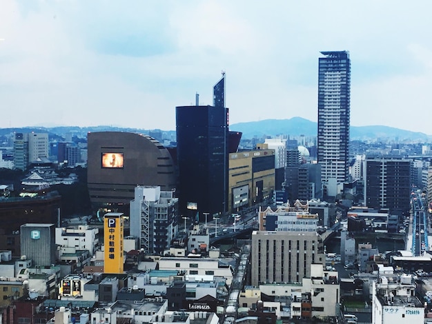 Photo view of cityscape against cloudy sky