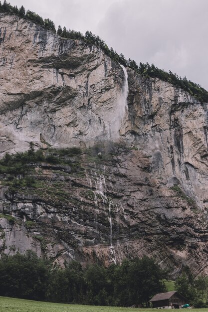 View closeup waterfall Staubbach fall in mountains, valley of waterfalls in national park of Lauterbrunnen, Switzerland, Europe. Summer landscape, sunshine weather, dramatic blue sky and sunny day