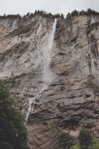 View closeup waterfall Staubbach fall in mountains, valley of waterfalls in national park of Lauterbrunnen, Switzerland, Europe. Summer landscape, sunshine weather, dramatic blue sky and sunny day