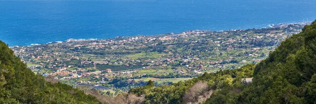 View of the coastal city Puerto de Tazacorte from the mountain with the sea in the background from above Houses or holiday accommodation by the ocean in the tourist destination of La Palma Spain