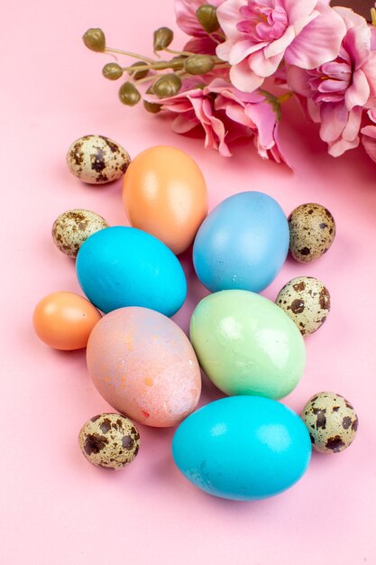 above view colored easter eggs on pink surface