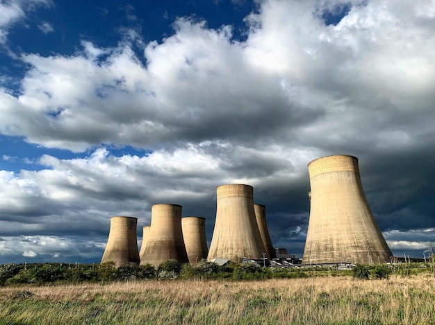 Photo view of cooling towers against blue and  cloudy sky ratcliffe on soar coal fired power station