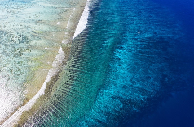 サンゴ礁の紺碧の水の背景を上から見る 空から見た夏の海 旅行のイメージ