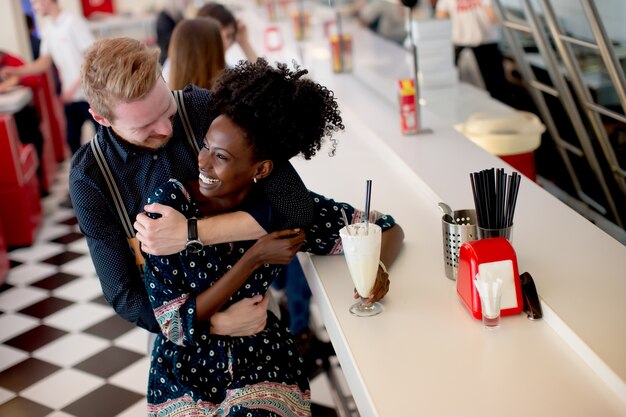 View at couple hugging by the bar in the diner