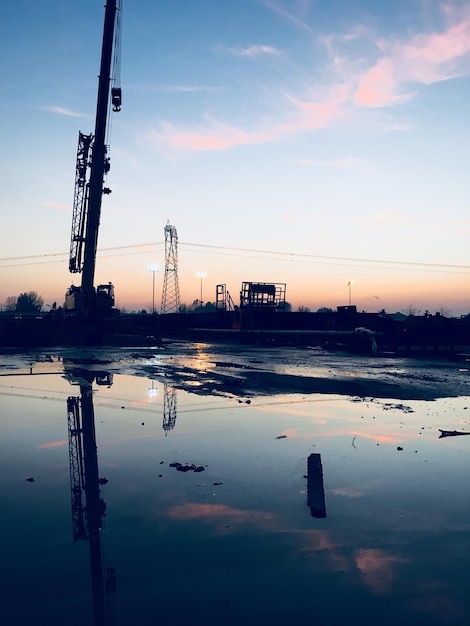 Photo view of crane against sky during sunset