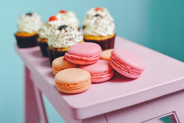 view of cup cakes and macaroon on pink table