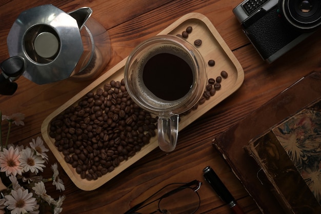 Above view cup of coffee and moka pot on wooden table.