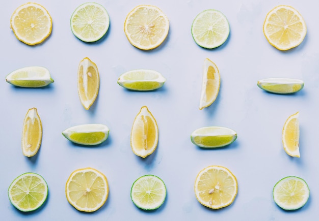 Above view at cutted lemons and limes on grey background