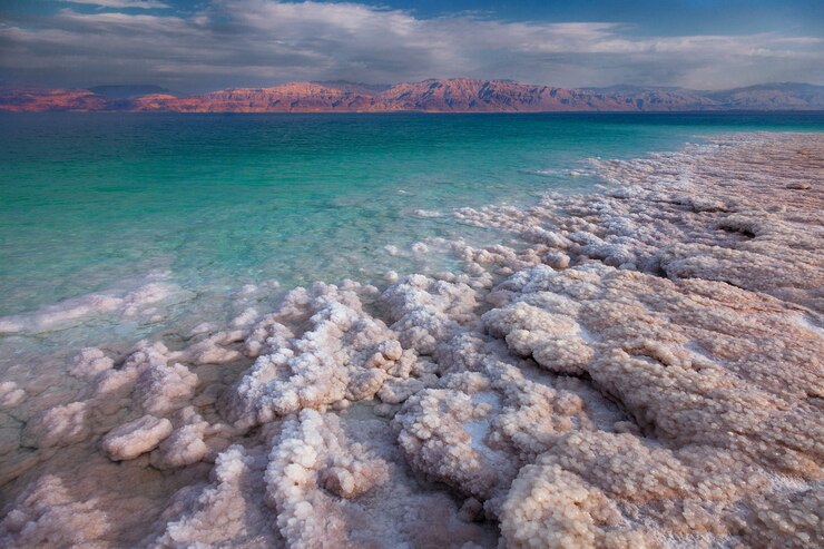 View of Dead Sea coastline. Salt crystals at sunset. Salty sea shore