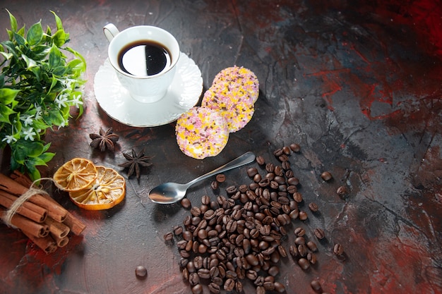 Above view of delicious sugar cookies and a cup of coffee flower pot dried lemons cinnamon slices beans on dark mix colors background