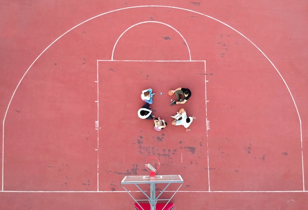 Above view of determined basketball playersstanding on court at daytime