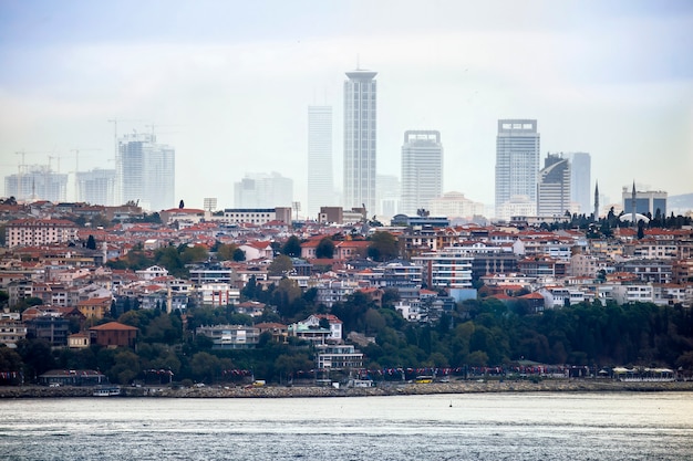 View of a district with residential and high modern buildings in Istanbul, Bosphorus Strait on the foreground, Turkey