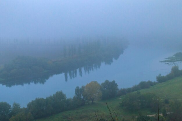 View of the Dniester river covered with a thick morning mist in autumn time