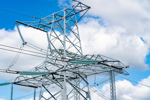 View of electric supply station Dark shadow of high voltage line High voltage pylons against blue sky background