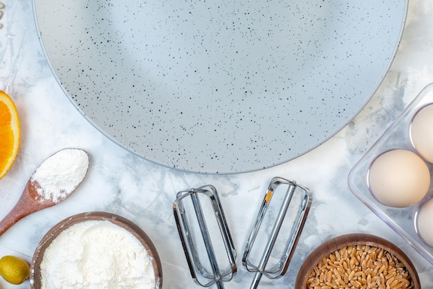 Above view of empty gray plate and ingredients for the healthy food set on ice table