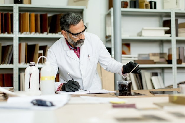 Photo view at engineer in the laboratory examines ceramic tiles