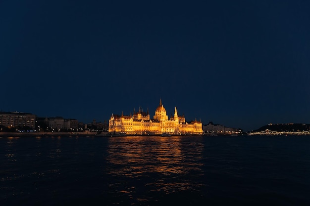 View of the evening city on the river bank lighting the parliam