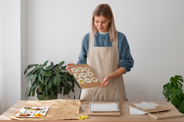 Photo view of female artisan pressing flowers