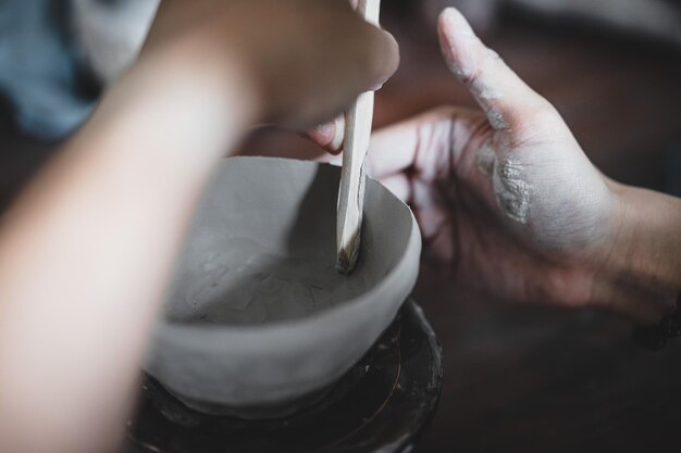 View of female hands works with clay makes future ceramic plate
ceramic artist makes classes of hand building in modern pottery
workshop creative people handcrafted design