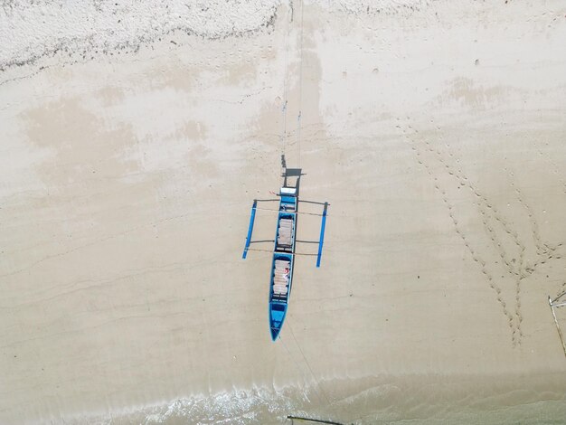 Photo view of fishing boats leaning on the beach