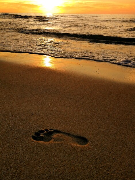 Foto vista dell'impronta sulla spiaggia durante il tramonto