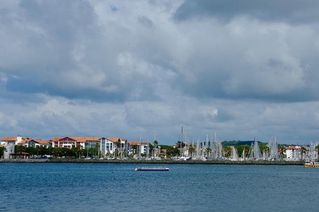 Photo view on the french coastal town hendaye from spanish side sea border between spain and france dramatic grey cloudscape