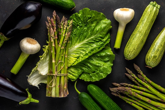 view of fresh asparagus with vegetables on a black table