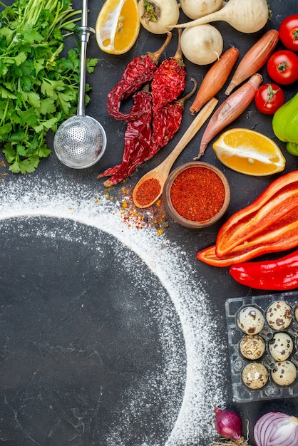 Above view of fresh various foods set and free space with flour around on dark color background