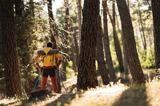 View from behind of african man hiking through the forest