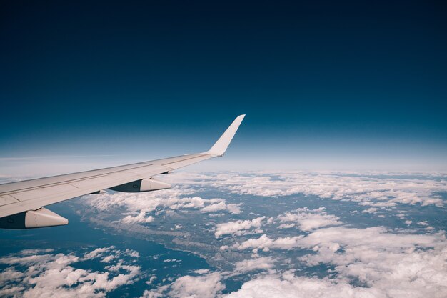 クロアチアの海岸の上の雲の上の飛行機の窓からの眺め